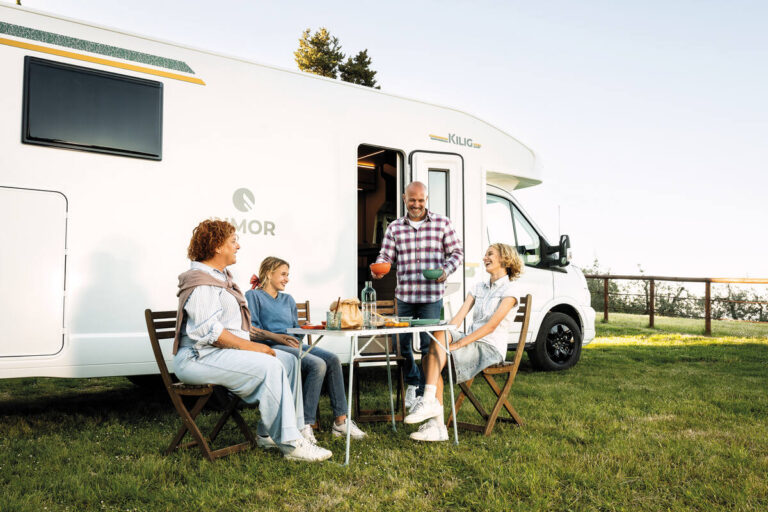 Familia comiendo junto a una autocaravana Rimor Kilig